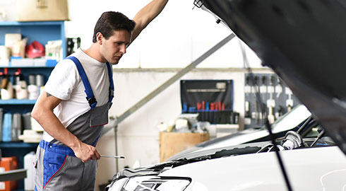 Technician Analyzing Engine Under Car Hood